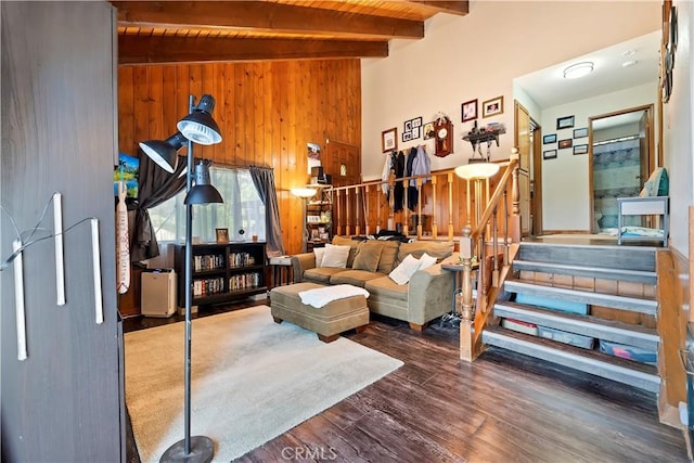 living area with beamed ceiling, wooden ceiling, wooden walls, wood finished floors, and stairs