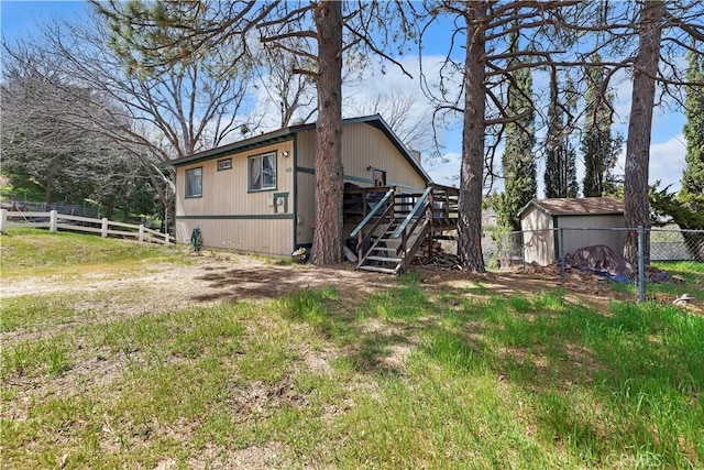 view of side of home with stairway, fence, and a wooden deck