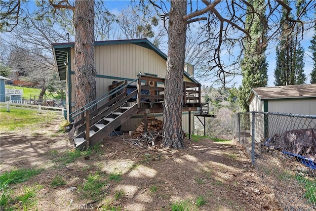 exterior space with fence, a wooden deck, and stairs