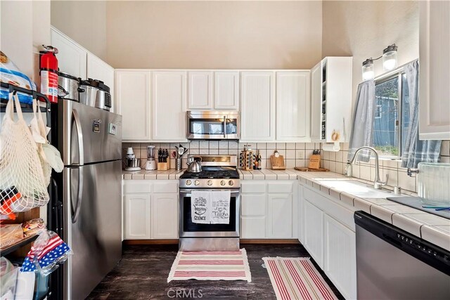 kitchen featuring stainless steel appliances, tile countertops, and a sink