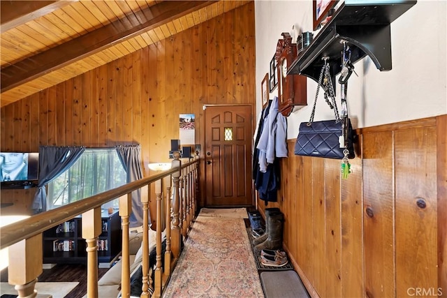 interior space featuring wooden walls, wooden ceiling, and beam ceiling