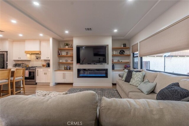 10057 Faywood, Bellflower, CA 90706 - living area with recessed lighting, a toaster, light wood-type flooring, a glass covered fireplace, and visible vents