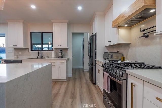 10057 Faywood, Bellflower, CA 90706 - kitchen with decorative backsplash, custom range hood, a sink, black refrigerator, and range with gas stovetop