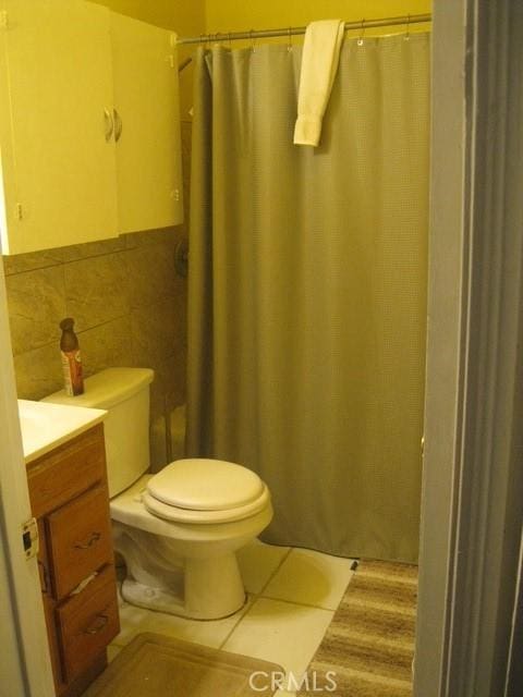 2927 S Genesee Ave, Los Angeles, CA 90016 - full bath with tile patterned flooring, tile walls, toilet, vanity, and curtained shower