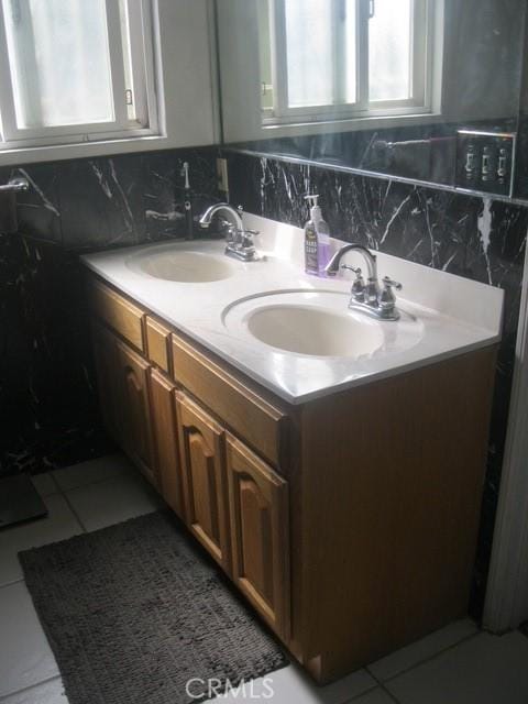 2927 S Genesee Ave, Los Angeles, CA 90016 - bathroom featuring tile patterned floors, decorative backsplash, double vanity, and a sink
