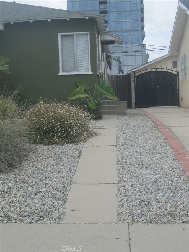 2927 S Genesee Ave, Los Angeles, CA 90016 - view of home's exterior with stucco siding, a gate, and a shingled roof
