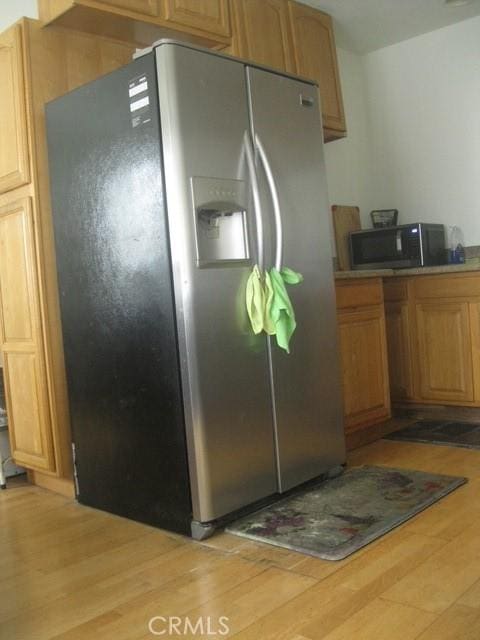2927 S Genesee Ave, Los Angeles, CA 90016 - kitchen featuring light wood-type flooring, black microwave, and stainless steel fridge with ice dispenser