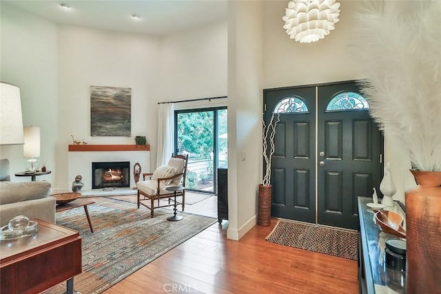 21025 Lemarsh St Unit G39, Chatsworth, CA 91311 - foyer with a towering ceiling, wood finished floors, a warm lit fireplace, and baseboards