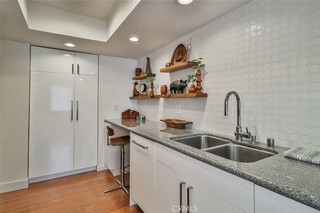 21025 Lemarsh St Unit G39, Chatsworth, CA 91311 - kitchen featuring a sink, light wood-style flooring, recessed lighting, white cabinetry, and dark stone counters