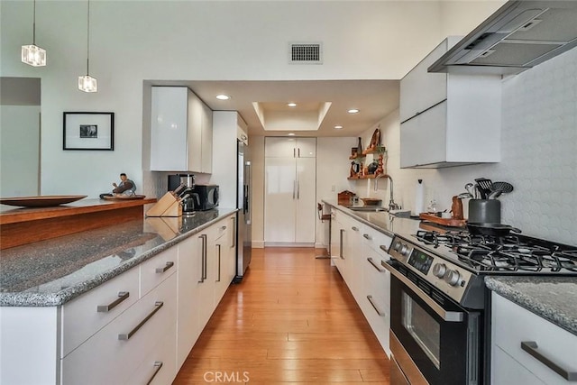 21025 Lemarsh St Unit G39, Chatsworth, CA 91311 - kitchen featuring stainless steel appliances, a sink, wall chimney range hood, white cabinets, and light wood finished floors