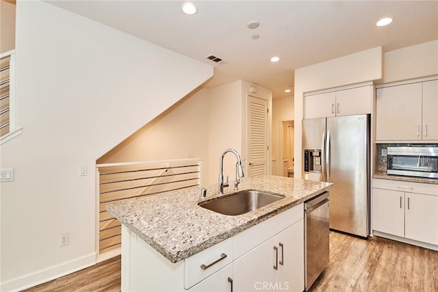 kitchen with a sink, visible vents, stainless steel appliances, recessed lighting, and light wood finished floors