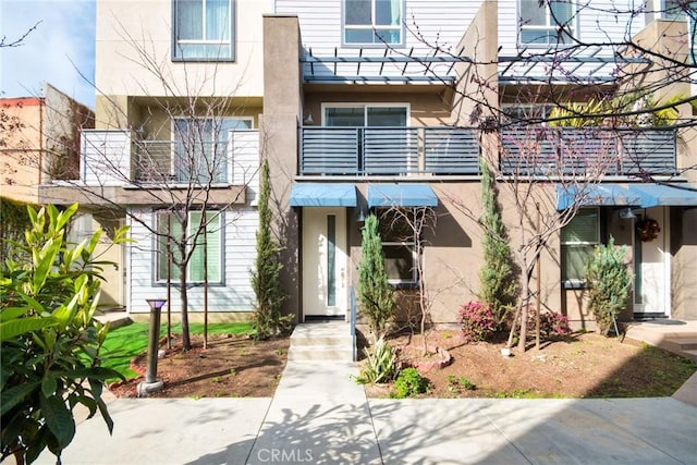 view of front of property with stucco siding and a balcony