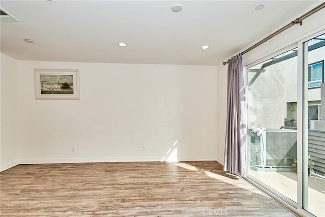 unfurnished room with visible vents, light wood-type flooring, recessed lighting, and baseboards