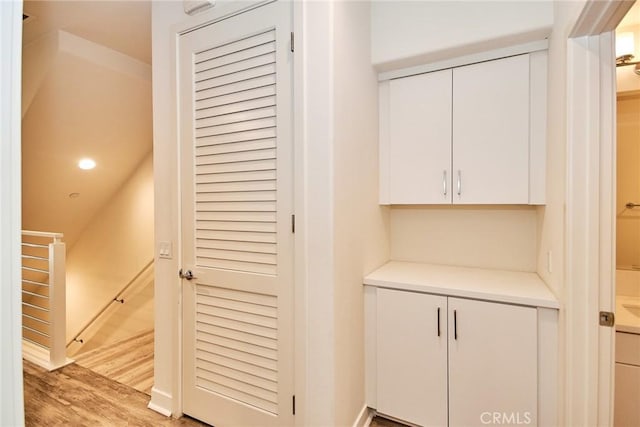 hall featuring recessed lighting, an upstairs landing, and light wood-type flooring