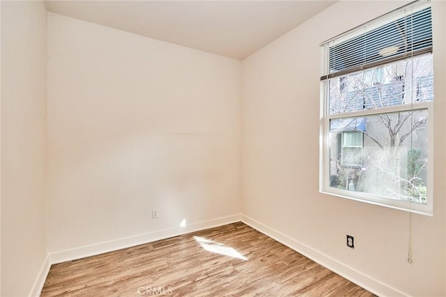 empty room with baseboards and light wood-style flooring