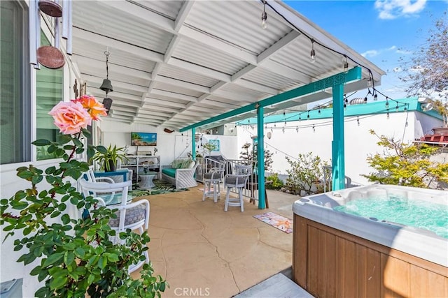 view of patio / terrace featuring fence and a hot tub