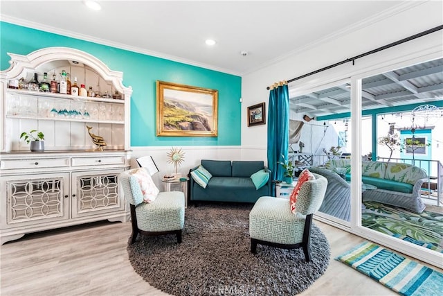 sitting room with crown molding, recessed lighting, wainscoting, and wood finished floors