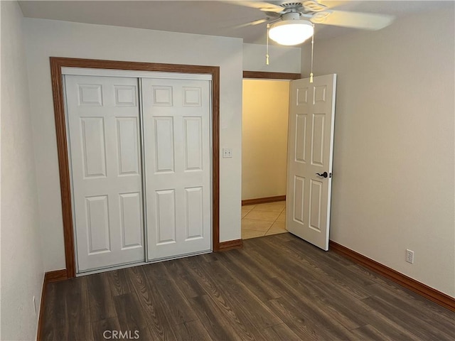8740 S Loop Blvd, California City, CA 93505 - unfurnished bedroom featuring dark wood-style flooring, ceiling fan, baseboards, and a closet