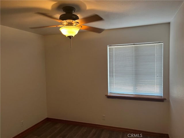 8740 S Loop Blvd, California City, CA 93505 - spare room featuring dark wood-style flooring, baseboards, and ceiling fan