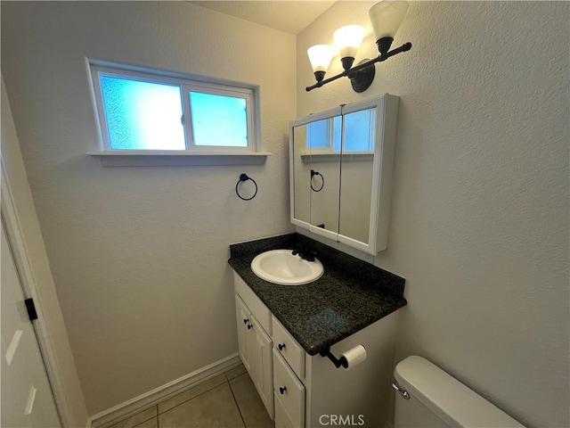 8740 S Loop Blvd, California City, CA 93505 - half bathroom featuring toilet, vanity, baseboards, tile patterned floors, and a notable chandelier