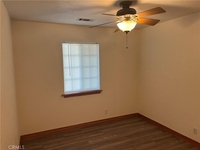 8740 S Loop Blvd, California City, CA 93505 - unfurnished room with dark wood-type flooring, baseboards, visible vents, and ceiling fan