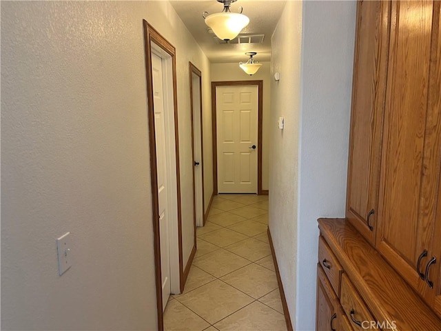 8740 S Loop Blvd, California City, CA 93505 - hall featuring light tile patterned flooring, a textured wall, baseboards, and visible vents
