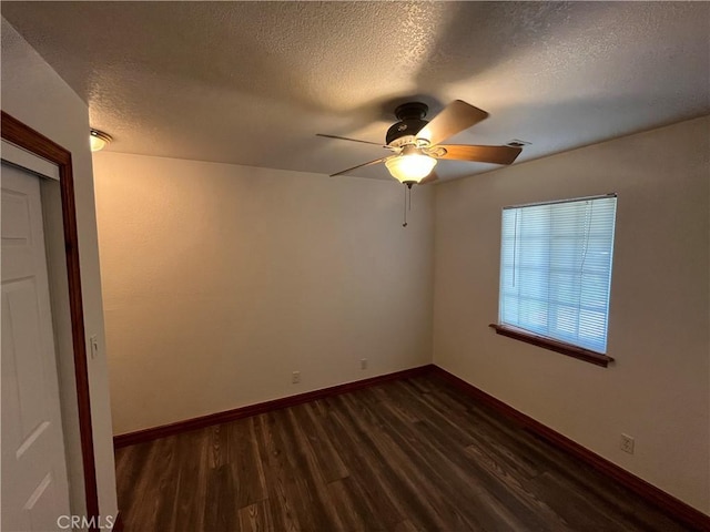 8740 S Loop Blvd, California City, CA 93505 - empty room with dark wood finished floors, baseboards, a ceiling fan, and a textured ceiling