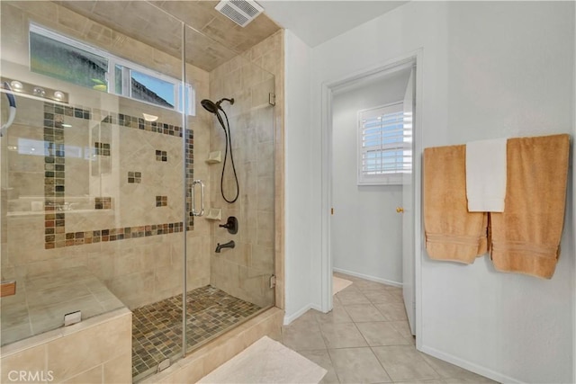 bathroom featuring baseboards, visible vents, a shower stall, and plenty of natural light