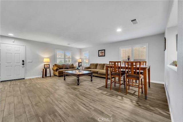 living area featuring recessed lighting, visible vents, wood finished floors, and baseboards