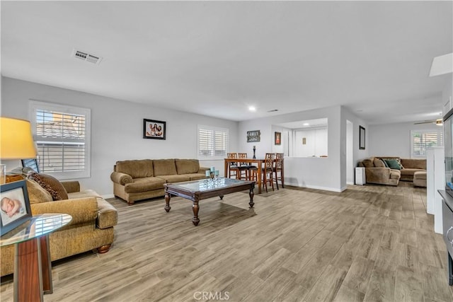 living area featuring visible vents, recessed lighting, light wood finished floors, and baseboards