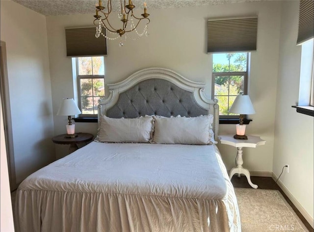 bedroom with baseboards and a notable chandelier