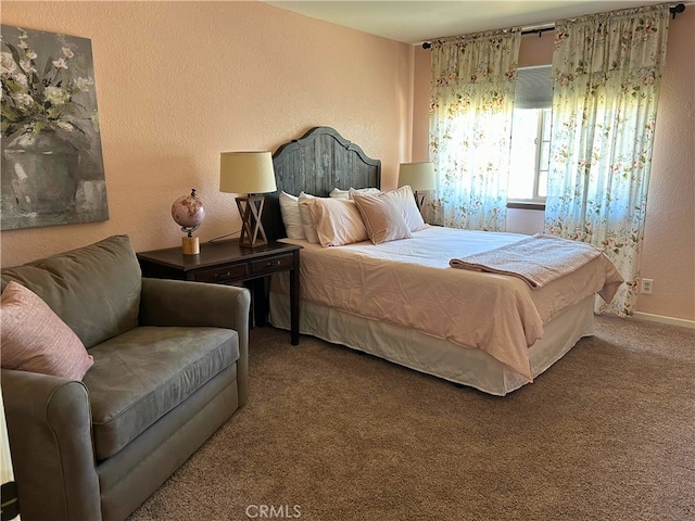 bedroom with carpet floors and a textured wall
