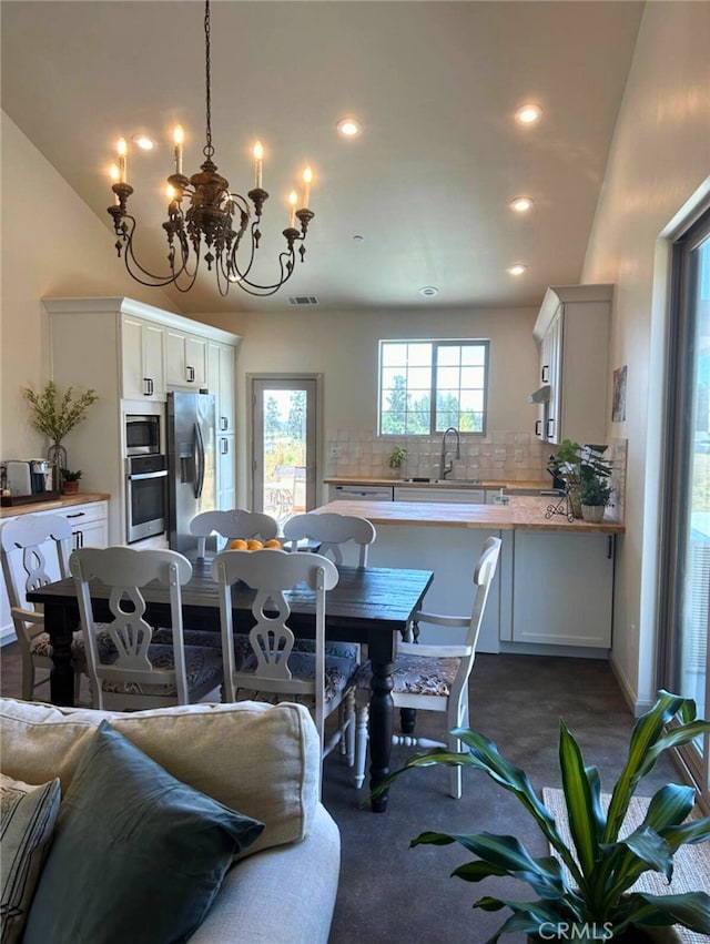 dining area featuring visible vents, recessed lighting, dark carpet, and an inviting chandelier