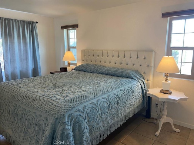 tiled bedroom with multiple windows and baseboards