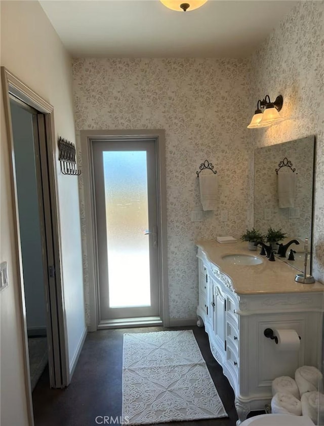 bathroom featuring wallpapered walls, baseboards, vanity, and a healthy amount of sunlight