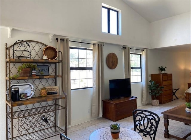 living room with light tile patterned floors and a high ceiling