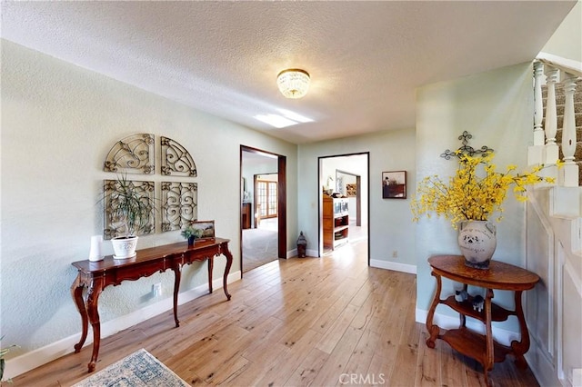 1160 Easy Ln, Nipomo, CA 93444 - corridor with light wood-style floors, a textured ceiling, and baseboards