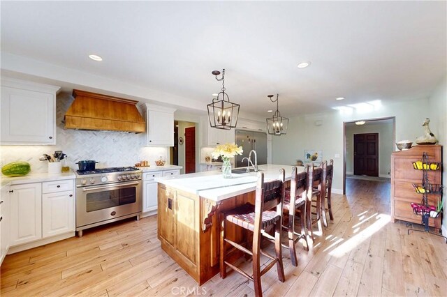1160 Easy Ln, Nipomo, CA 93444 - kitchen featuring high end stainless steel range, custom exhaust hood, light countertops, white cabinetry, and recessed lighting