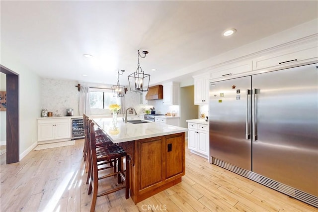 1160 Easy Ln, Nipomo, CA 93444 - kitchen featuring premium appliances, premium range hood, a sink, beverage cooler, and light wood-type flooring