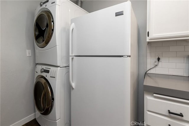 3913 N Virginia Rd Unit 207, Long Beach, CA 90807 - washroom featuring cabinet space, stacked washer and clothes dryer, and baseboards
