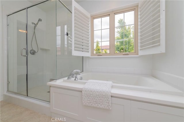 bathroom with a shower stall and a bath