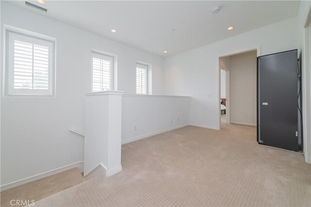 empty room featuring recessed lighting, baseboards, visible vents, and light carpet