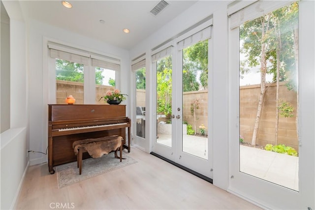 interior space with french doors, recessed lighting, wood finished floors, and visible vents