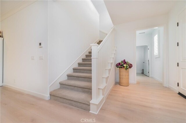 stairway with baseboards and wood finished floors