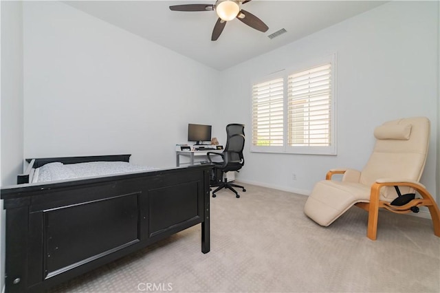 office area with visible vents, a ceiling fan, baseboards, and light carpet