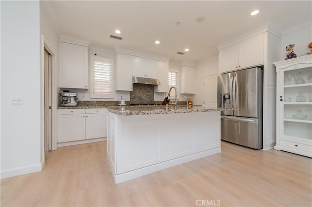 kitchen with stainless steel fridge with ice dispenser, light wood-style flooring, under cabinet range hood, and white cabinetry