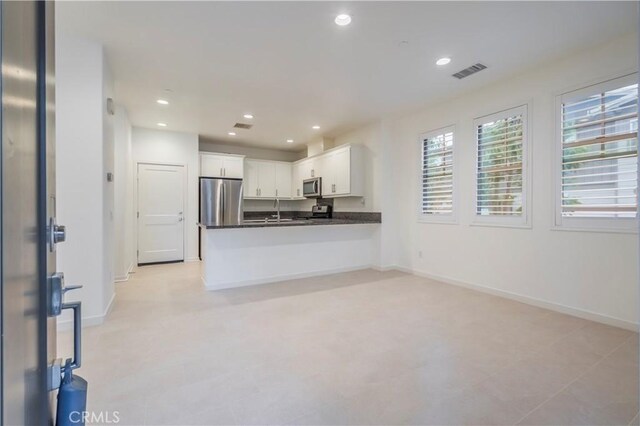 556 W Baseline Rd, Claremont, CA 91711 - kitchen featuring a sink, stainless steel appliances, visible vents, dark countertops, and white cabinets