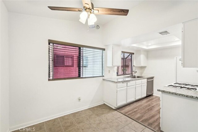 1251 S Meadow Ln Unit 154, Colton, CA 92324 - kitchen featuring a sink, baseboards, stainless steel dishwasher, and white cabinetry
