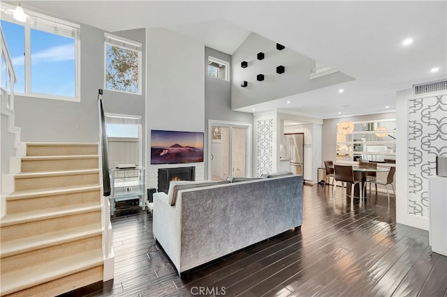 1541 Westcastle, West Covina, CA 91791 - living room featuring stairs, a towering ceiling, dark wood-type flooring, a warm lit fireplace, and recessed lighting