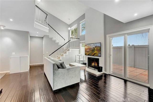 1541 Westcastle, West Covina, CA 91791 - living area with stairway, a lit fireplace, a high ceiling, dark wood-style floors, and baseboards